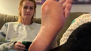 Sexy gamer meisje krijgt haar voeten gemasseerd en aanbeden door een volwassen vrouw