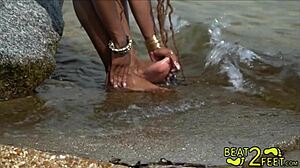 נערה צעירה ומקורזלת מקבלת את רגליה רטובות על החוף