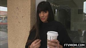 Kıvrımlı olgun bir kadın kahvesinin tadını çıkarıyor ve kaldırımda biraz tenini ortaya çıkarıyor